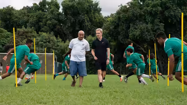 Thomas Rongen (Michael Fassbender) walking with a coach during training drills