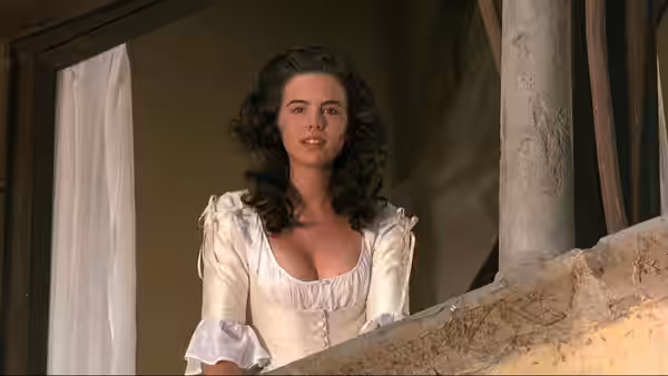 Hero (Kate Beckinsale) standing on a stone balcony in a white dress