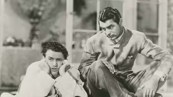 Mike Connor (James Stewart) and C.K. Dexter Haven (Cary Grant) sit together indoors