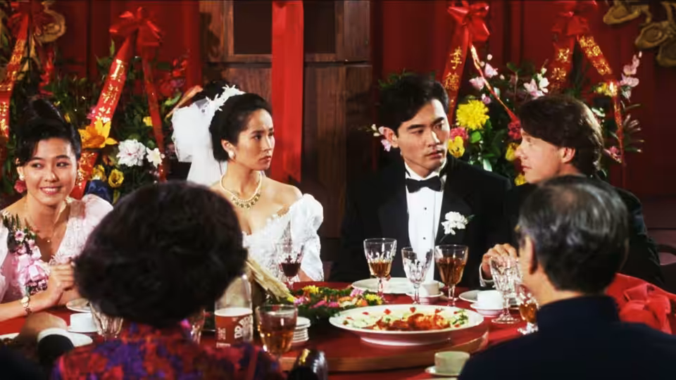 Bride and groom sit at a round table during a festive Chinese wedding banquet