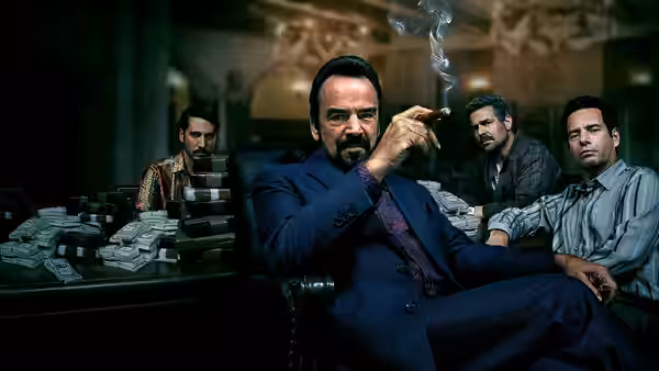 Pablo Escobar (Wagner Moura) smoking a cigar in an office surrounded by stacks of cash