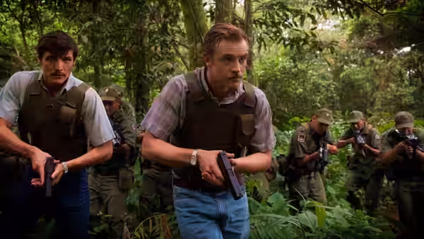 Javier Peña (Pedro Pascal) and Steve Murphy (Boyd Holbrook) holding guns in a jungle with soldiers