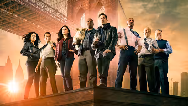 A group of detectives poses on a rooftop ledge with the Brooklyn Bridge behind