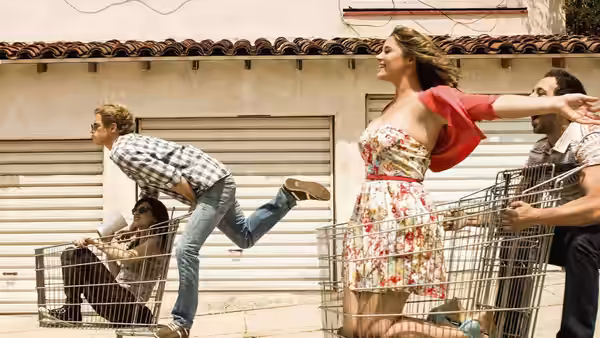 Jimmy (Chris Geere) and Gretchen (Aya Cash) racing with shopping carts