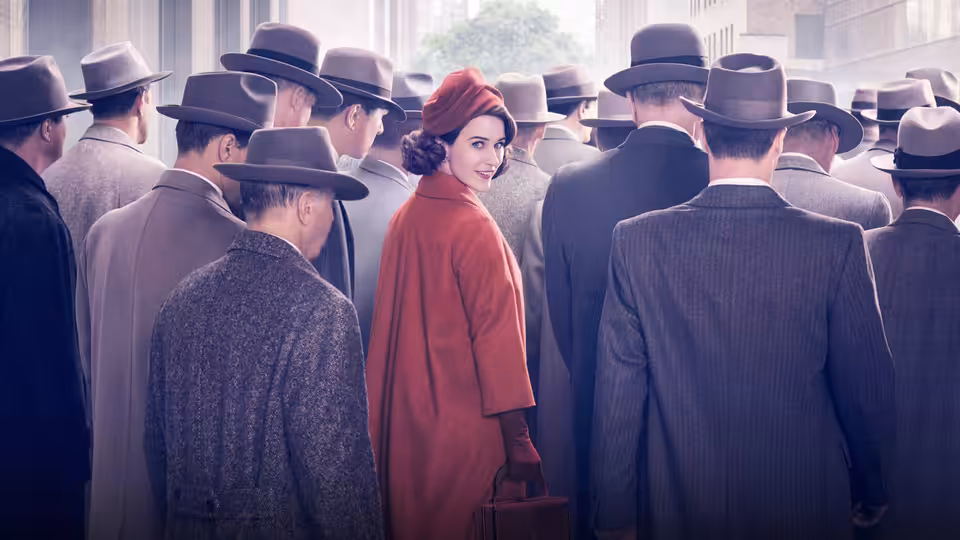 Midge Maisel (Rachel Brosnahan) walking through a crowd of suited men