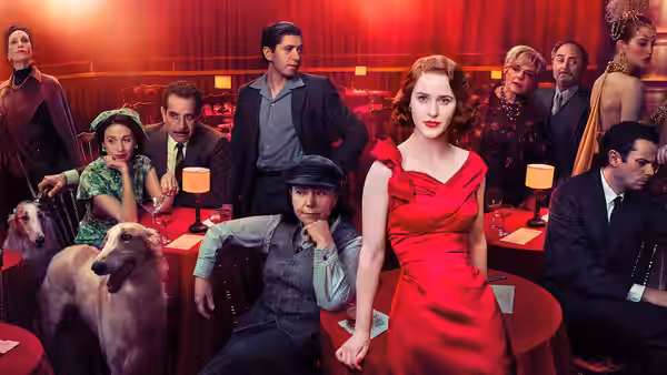 Midge Maisel (Rachel Brosnahan) standing in a red dress among a group in a nightclub