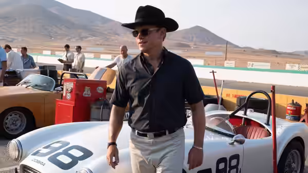 Carroll Shelby (Matt Damon) walking beside a white race car at the track