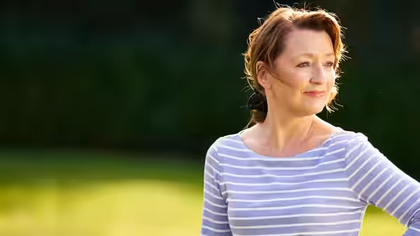 Cathy (Lesley Manville) standing outside with hair blowing in the wind