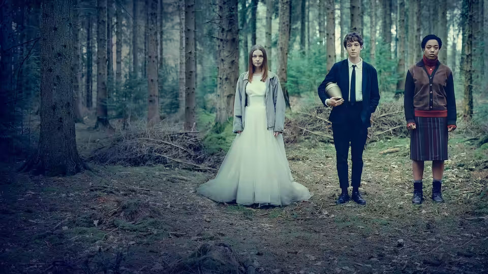 Alyssa (Jessica Barden) in a wedding dress stands in a forest beside James (Alex Lawther) holding a bowling pin and another girl