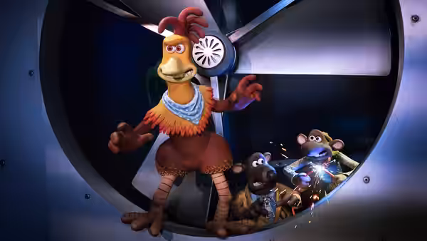 Chicken gestures beside a large fan while rats work below