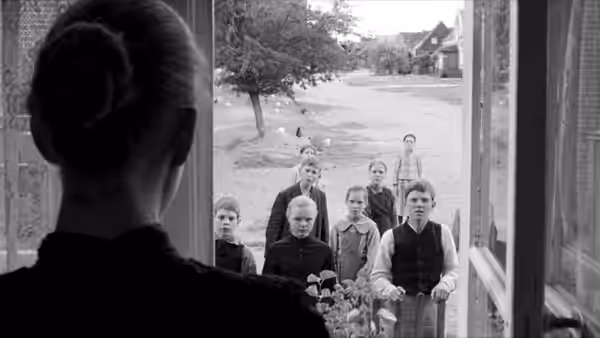 a woman looking out at a group of children gathered outside