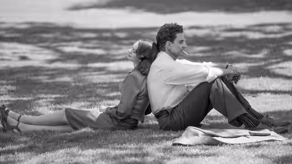 Felicia Montealegre (Carey Mulligan) and Leonard Bernstein (Bradley Cooper) sitting on grass