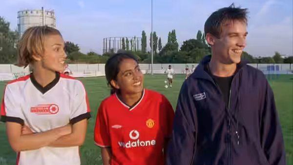 Jules (Keira Knightley), Jess (Parminder Nagra) and Joe (Jonathan Rhys Meyers) stand together on the football field