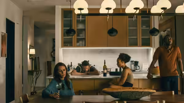 Amanda Sandford (Julia Roberts) at table while Clay Sandford (Ethan Hawke) and Ruth Scott (Myha'la Herrold) stand in kitchen