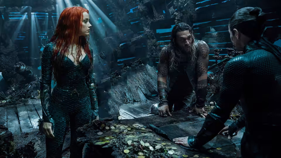 Mera and Arthur Curry confer with another man over a map in a flooded ruin