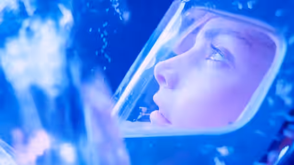 Lindsey Brigman (Mary Elizabeth Mastrantonio) looking through a diving helmet in water