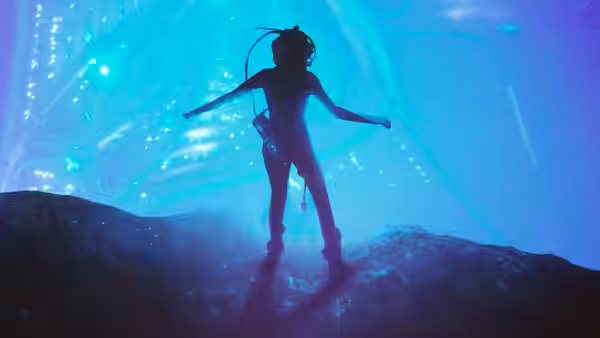 A diver standing on a rocky surface underwater with arms extended