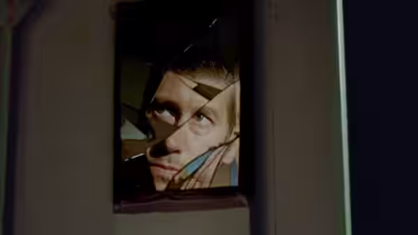 Holappa's face reflected in shards of a broken window