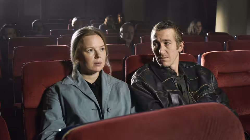 Ansa and Holappa seated side by side in a red cinema auditorium