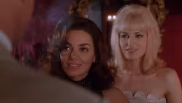 Christine Keeler (Joanne Whalley) and Mandy Rice-Davies (Bridget Fonda) smile at someone nearby