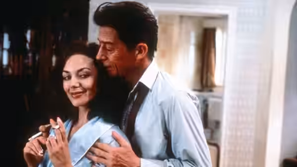 Stephen Ward (John Hurt) embraces Christine Keeler (Joanne Whalley) in a room