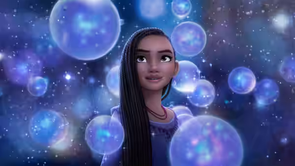 Asha (Ariana DeBose) gazes upward amid floating blue orbs in a starry void