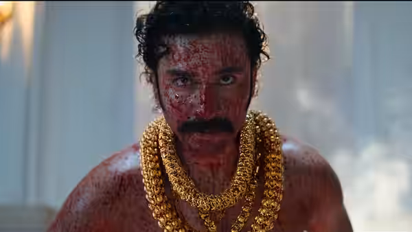 Jadal (Nani) faces forward, his face smeared red and layered in gold chains