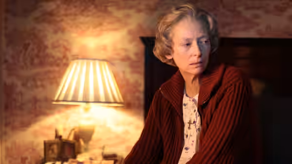 Rosalind (Tilda Swinton) looking aside in a bedroom illuminated by a lamp