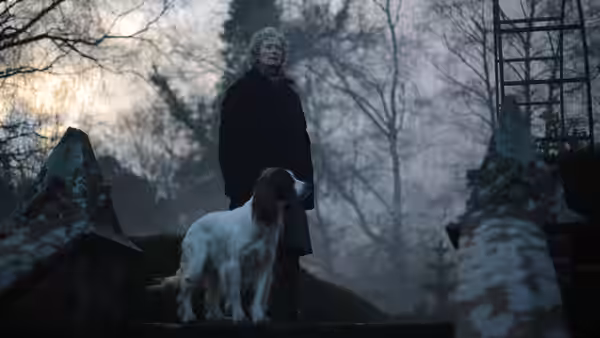 Rosalind (Tilda Swinton) standing outdoors with a dog in the fog