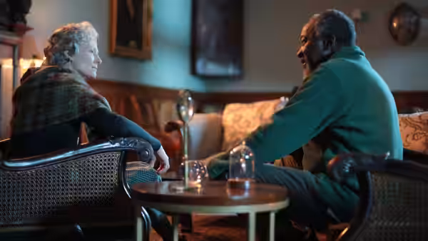 Rosalind (Tilda Swinton) conversing with Bill (Joseph Mydell) in a lounge