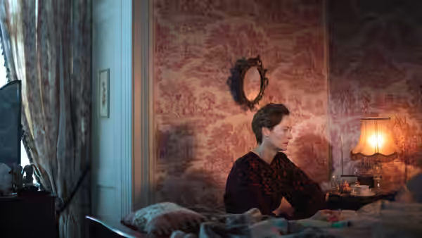 Julie (Tilda Swinton) sitting on the edge of a bed in her room
