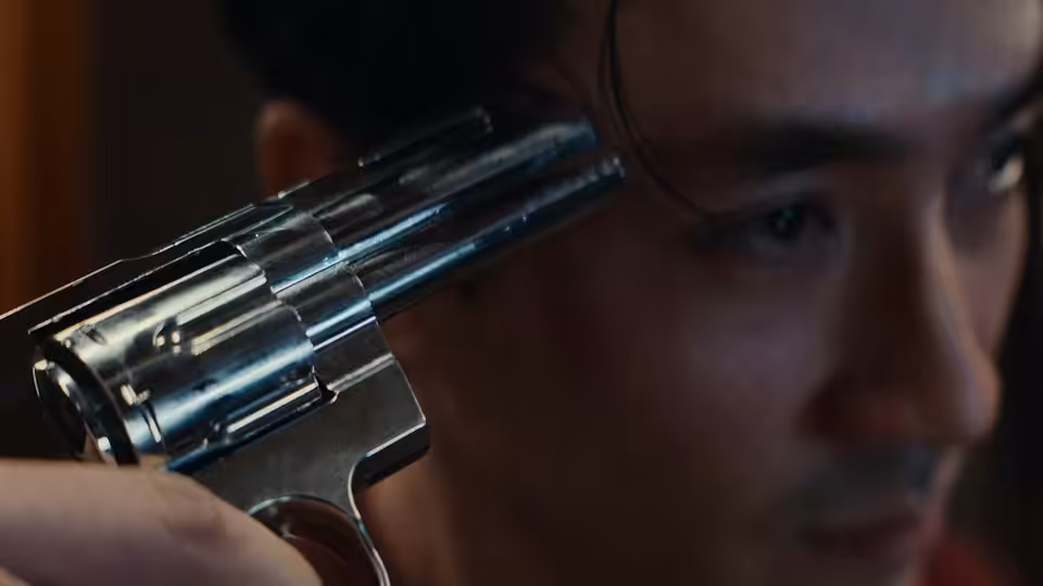 A revolver pressed against the side of a man's head