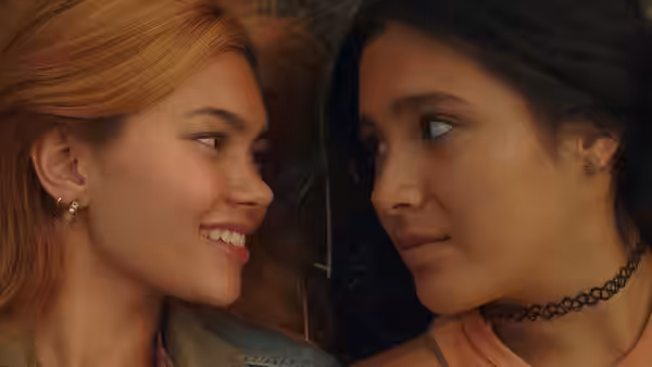 Close-up of two young women facing each other one smiling and one looking on