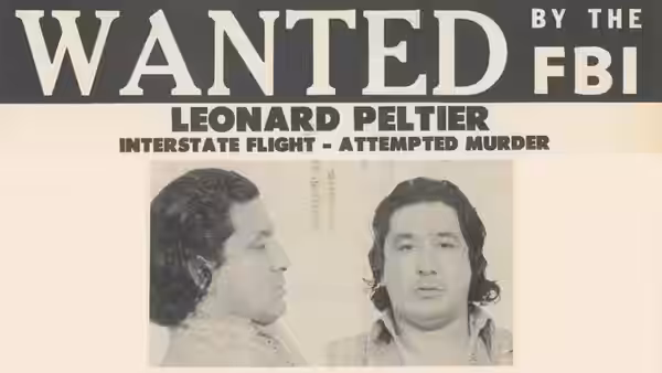 A wanted poster displays Leonard Peltier’s name and front and profile booking photographs
