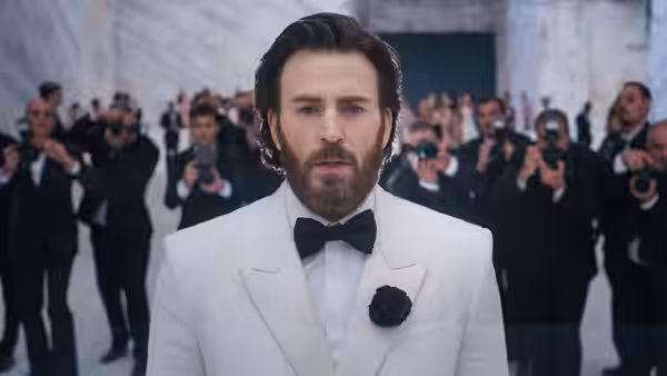 Mike Tyler (Chris Evans) in a white tuxedo surrounded by photographers