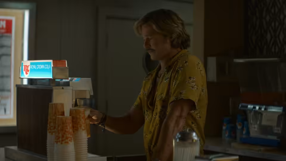 Cliff Booth (Brad Pitt) dispensing soda from a fountain machine