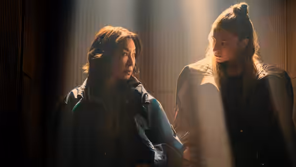 Olwen (Michelle Yeoh) and Cora (Hunter Schafer) face each other in a dim corridor