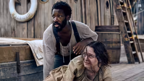 Clemens (Corey Hawkins) leaning over Anna (Aisling Franciosi) on deck