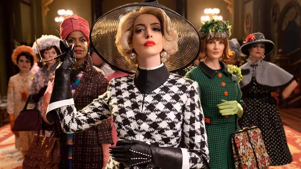 Grand High Witch (Anne Hathaway) gesturing among witches in a grand hall