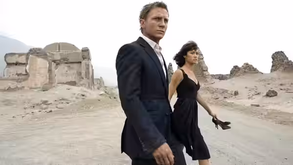 James Bond (Daniel Craig) and Camille (Olga Kurylenko) walking through desert ruins
