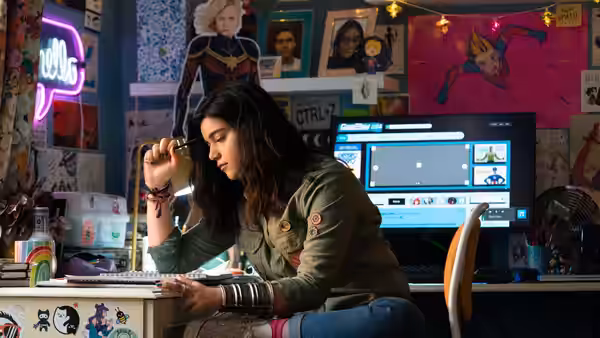 Kamala Khan (Iman Vellani) examining an object at her desk