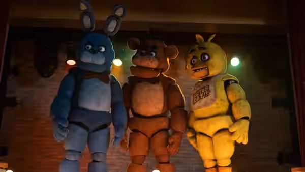 Three animatronic characters standing on a stage with brick walls behind them