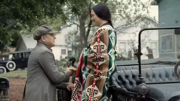 Ernest Burkhart (Leonardo DiCaprio) talking with Mollie Burkhart (Lily Gladstone) by a car