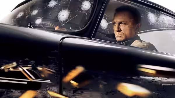 James Bond (Daniel Craig) driving a black car with bullet holes in windshield