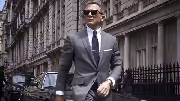 James Bond (Daniel Craig) walking on a city street in a gray suit