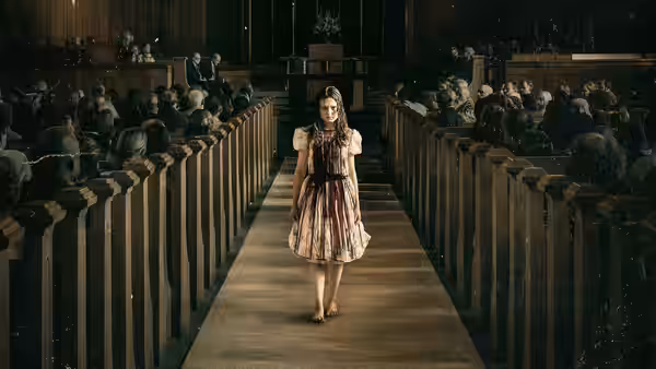 Young girl in stained dress walks down aisle of crowded church
