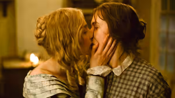 Charlotte Murchison (Saoirse Ronan) kisses Mary Anning (Kate Winslet) in a candlelit room