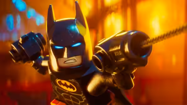 Batman grips a grappling gun with both hands extended