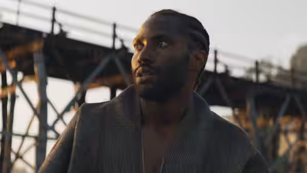 Joshua (John David Washington) gazing upward near large metal bridge