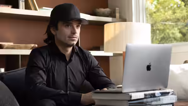 Vlad Tenev (Sebastian Stan) using a laptop in an office